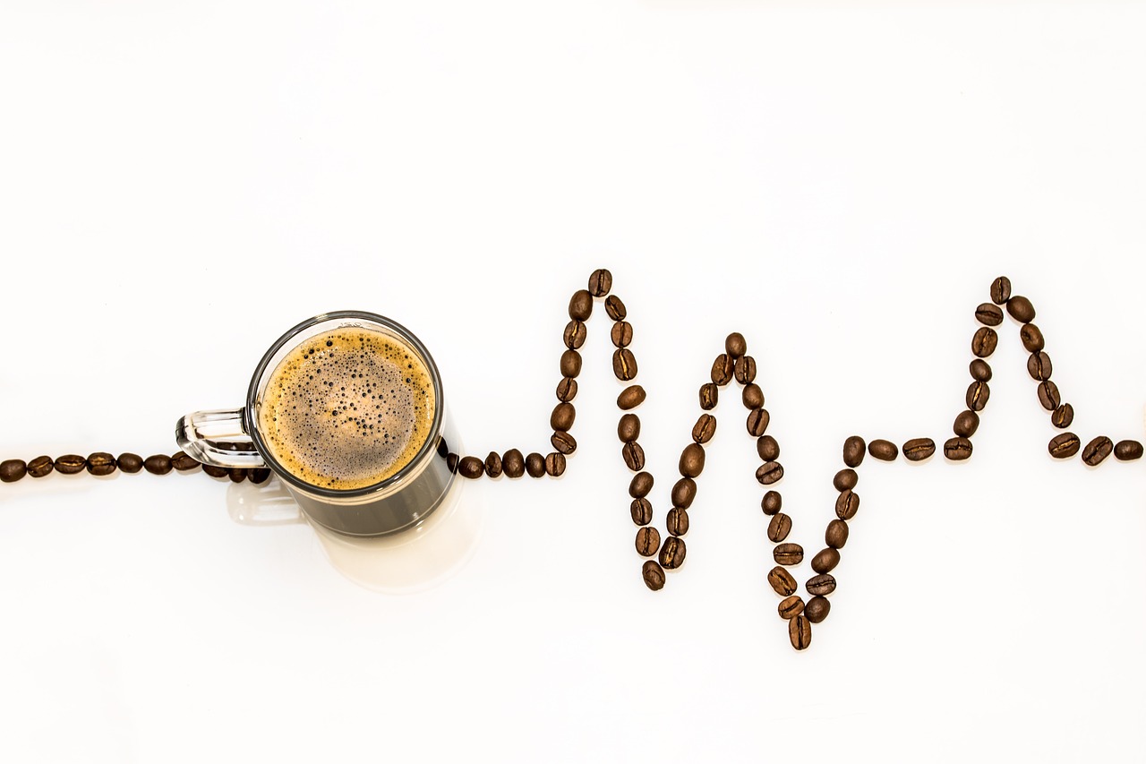 Tazza di caffè fumante su un tavolo, simbolo dell'abitudine quotidiana e del suo impatto sul colesterolo.