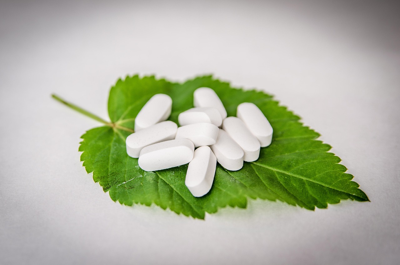 Integratori di magnesio in diverse forme: capsule, polvere e compresse su sfondo bianco.