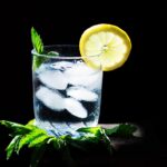 Due bicchieri d'acqua fredda su un tavolo, a lato di un piatto con cibo appena servito.