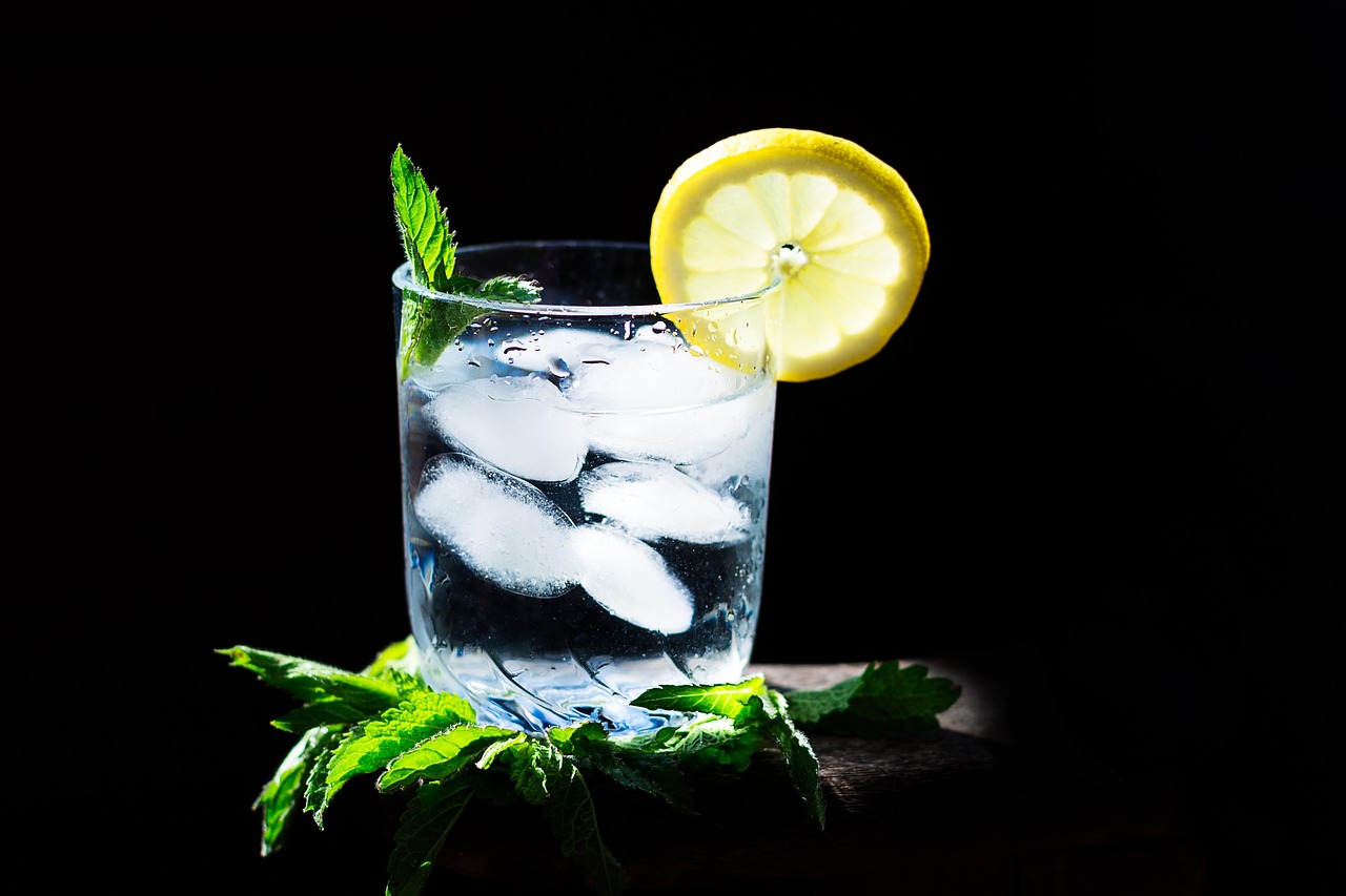 Due bicchieri d'acqua fredda su un tavolo, a lato di un piatto con cibo appena servito.