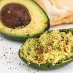 Avocado fresco su un tagliere, pronto per essere utilizzato in ricette salutari per il colesterolo.