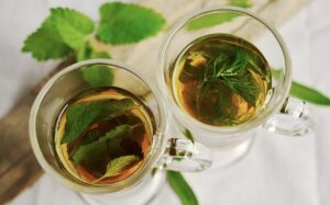 Tisane naturali per abbassare il colesterolo alto: diverse erbe in un contenitore sulla tavola.
