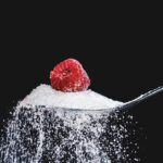 Scatola di cereali con etichetta che evidenzia zuccheri aggiunti e ingredienti 'sani'.
