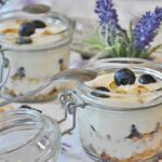 Vari alimenti fermentati ricchi di probiotici naturali, come yogurt e crauti, su sfondo neutro.