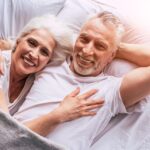 Uomo e donna over 50 che discutono sulle ore di sonno necessarie per una buona salute.