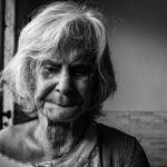 Donna che controlla un integratore di vitamina D, simbolo di carenza nutrizionale in Italia.